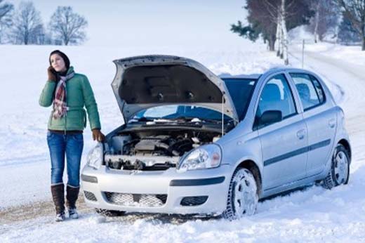 Девушка на заснеженной дороге - автомобиль отказывается заводиться в мороз