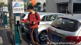 Китаец у зарядной станции для автомобилей