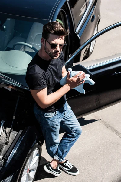High Angle View Young Man Sunglasses Wiping Hands Rag Car — стоковое фото